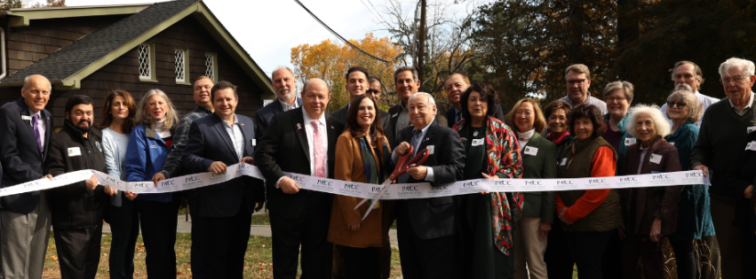 Photo of people standing cutting a ribbon